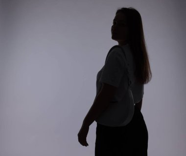 Gri arkaplanda çantası olan kadın silueti, metin için boşluk