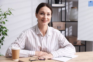 Gülümseyen çevrimiçi hoparlör. İçerideki masada web kamerasından görüntüsü olan webinar.