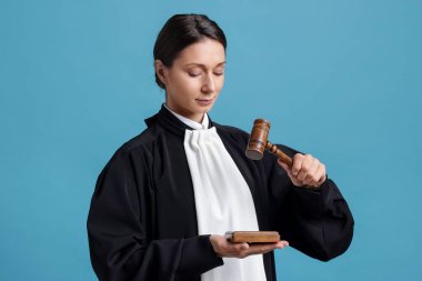 Açık mavi arkaplanda çekiç ve ses bloğuyla yargıla