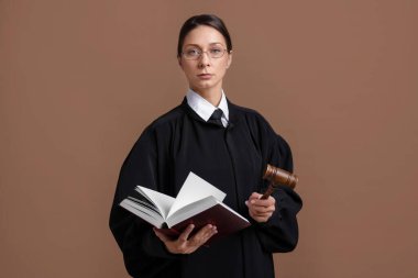 Açık kahverengi arkaplan üzerine kitap ve çekiçle yargıç