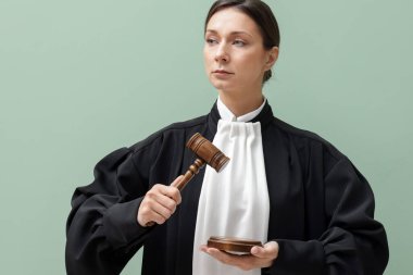 Açık yeşil arkaplanda çekiç ve ses engeli olan yargıç