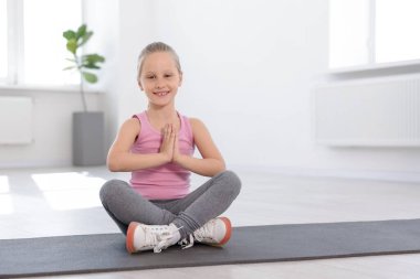 Kapalı alanda yoga yapan mutlu kız.