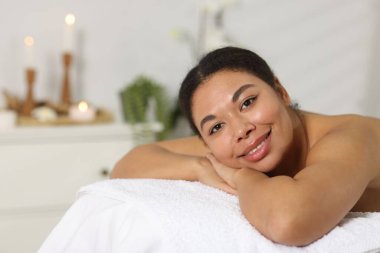 Güzel bir kadın masaj salonundaki masaj koltuğunda dinleniyor, mesaj atmak için yer var.