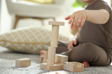 Evdeki ahşap yapı taşlarıyla oynayan sevimli küçük çocuk, yakın plan. Metin için boşluk