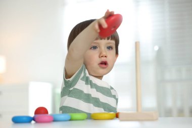 Masada oyuncak piramidiyle oynayan sevimli küçük çocuk.