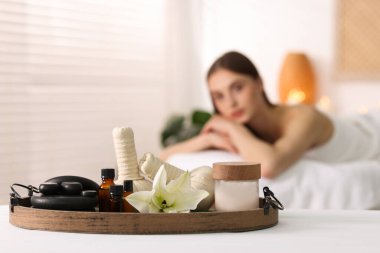 Kadın kuaförde dinleniyor, spa ürünlerine ve çiçeklere odaklanıyor