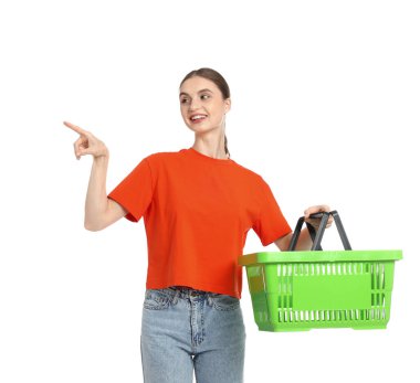 Plastik alışveriş sepetli kadın beyaz arka plandaki bir şeyi işaret ediyor.