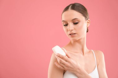 Pembe arka planda sabun çubuğu olan güzel bir kadın. Metin için boşluk