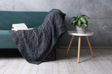 Evdeki kanepede yün ekose ve kitap.