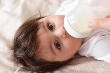 Babası bebeğini evde şişeyle besliyor, yakın plan.