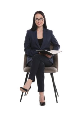 Ofis koltuğunda beyaz arka planda not defteri olan profesyonel psikolog.