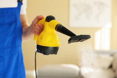 Evde buhar temizleyicisi olan kapıcı, yakın çekim.