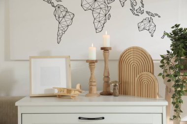 Duvarın yanındaki dolapta yanan mumlar ve diğer dekorlarla süslü şamdanlar.