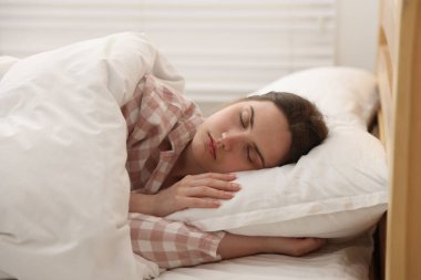 Evde yatakta uyuyan genç kadın.