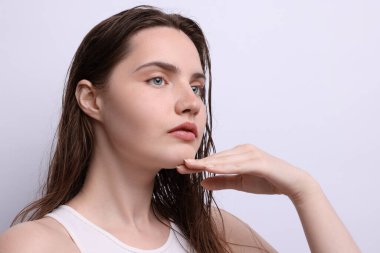 Açık gri arka planda doğal ten rengi olan güzel bir kadın, yakın plan.