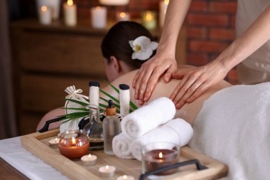 Spa salonunda kadın sırt masajı yaptırıyor.