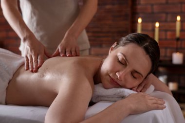 Spa salonunda kadın sırt masajı yaptırıyor.