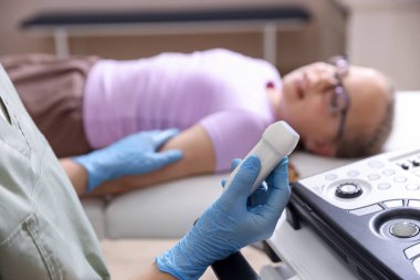 Ultrason makineli sonograf ve klinikteki muayene odasında kız, seçici odaklı.
