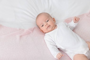 Evdeki yatakta uzanmış şirin küçük bebek, üst manzara. Metin için boşluk