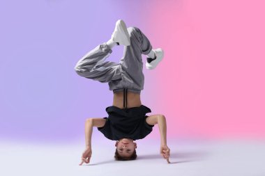 Renkli arka planda dans eden şık elbiseli çocuk.