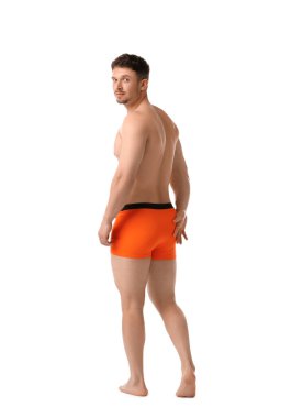 Beyaz arka planda turuncu iç çamaşırlı genç adam.