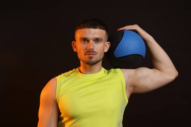 Siyah arka planda tıp topu olan adam.