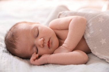 Yatma vakti. Yatakta uyuyan sevimli küçük bebek.