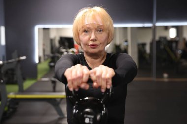 Beden dersinde kettlebell ile son sınıf kadın eğitimi.