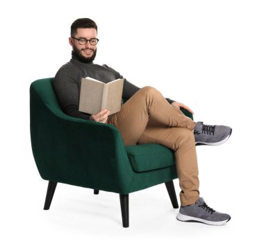 Kitabı olan gülümseyen adam beyaz arka planda koltukta dinleniyor.