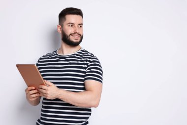 Beyaz arkaplanda tablet kullanan yakışıklı adam, metin için boşluk