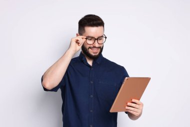 Yakışıklı adam beyaz zemin üzerine tablet kullanma