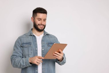 Beyaz arkaplanda tablet kullanan yakışıklı adam, metin için boşluk