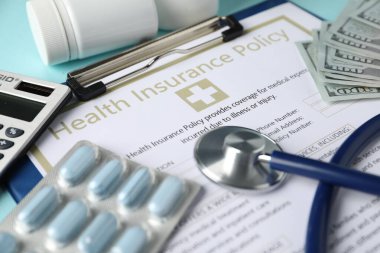 Sağlık sigortası poliçesi, haplar, para ve turkuaz arka plan steteskobu, yakın plan