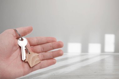 Emlakçı evin anahtarını tutuyor, yakın plan. Metin için boşluk