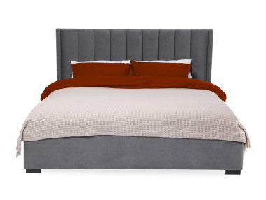 Beyaz arka planda güzel çarşaflarla yapılmış bir yatak.