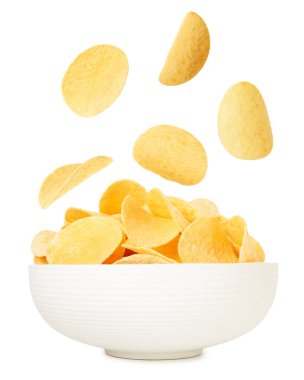 Lezzetli patates cipsleri beyaz arka planda kaseye düşüyor.