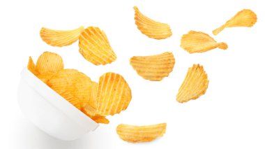 Lezzetli patates cipsleri beyaz arka planda kaseye düşüyor.