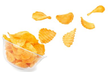 Lezzetli patates cipsleri beyaz arka planda kaseye düşüyor.