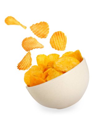 Lezzetli patates cipsleri beyaz arka planda kaseye düşüyor.