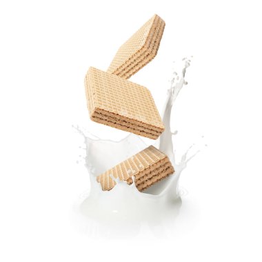 Lezzetli gevrek gofretler beyaz arka plana süt sıçratıyor.