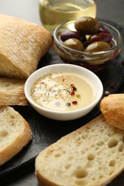 Siyah masada yağlı, zeytinli ve baharatlı dilimlenmiş ekmek, yakın plan.