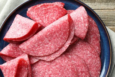 Ahşap masada leziz sosis dilimleri, üst manzara.