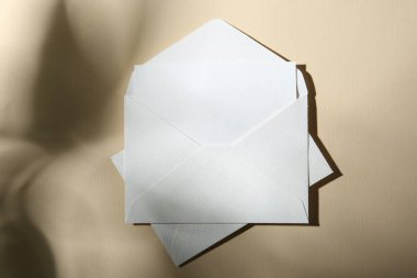 Bej arka planda boş tebrik kartı ve kağıt zarfları, üst görünüm