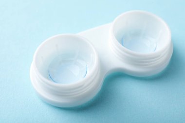 Açık mavi arkaplanda kontak lensi, yakın plan