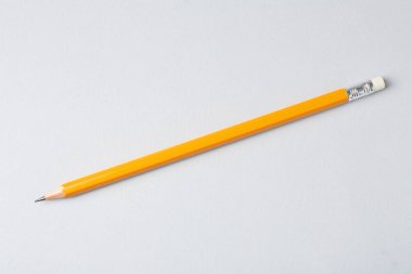 Gri arkaplanda keskin bir grafit kalem, üst görünümde.