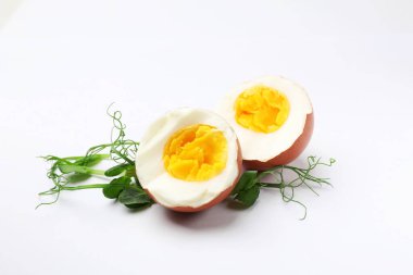 Haşlanmış yumurta ve beyaz arka planda mikro yeşillikler.