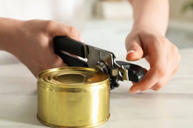 Beyaz masada konserve açacağıyla konserve açan kadın, yakın çekim