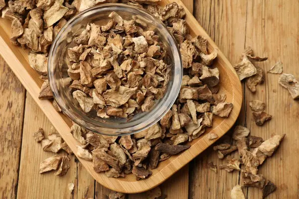 Kuru hindiba kökleri tabakta, ahşap masada, üst tarafta.