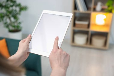 Evinde modern tabletli bir kadın, yakın çekim. Metin için boşluk