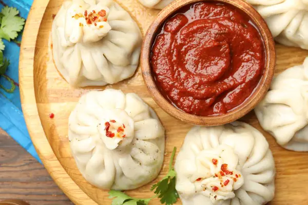 Ahşap masada sosla servis edilen nefis khinkali, üst manzara.